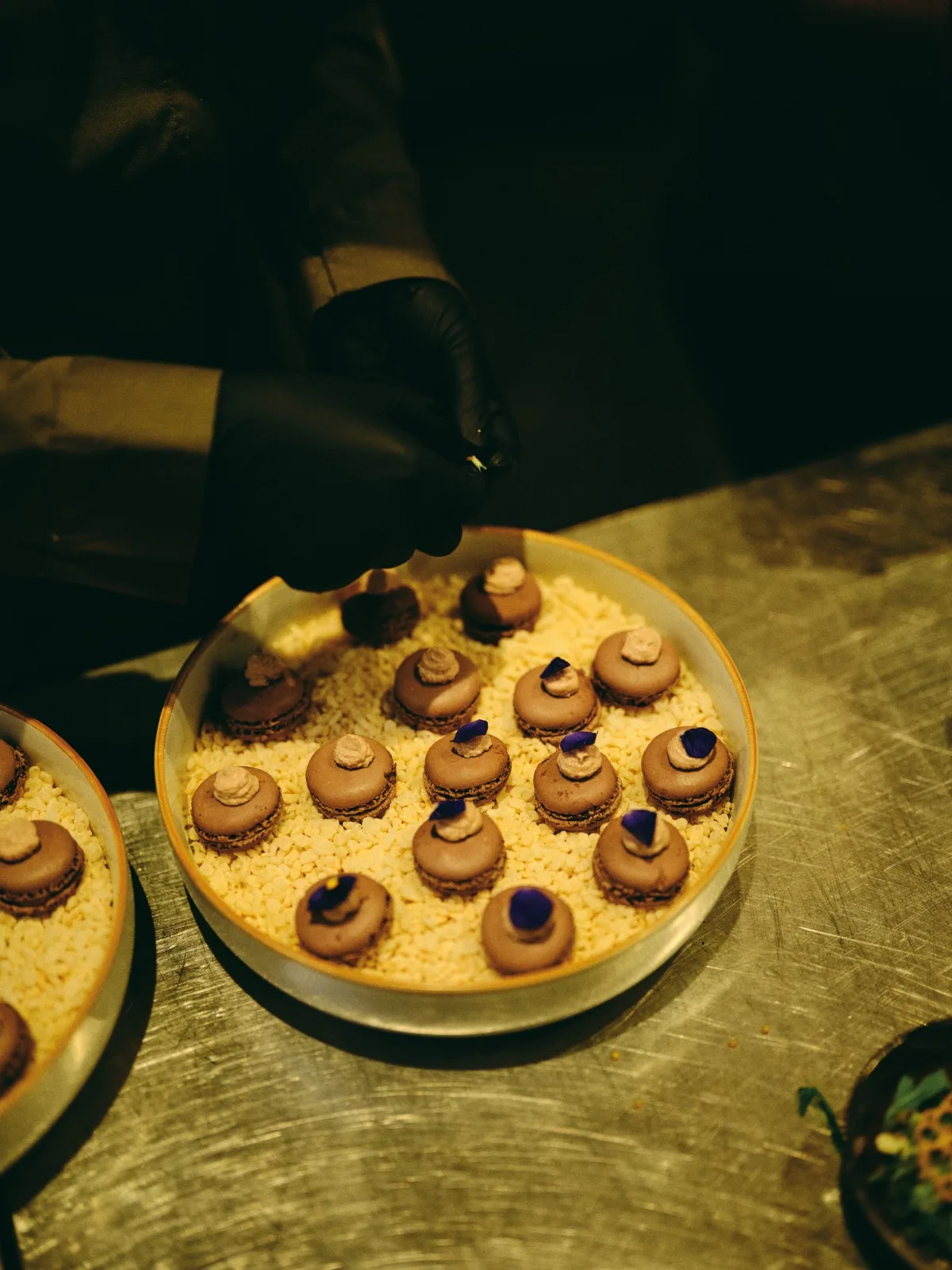 Chef werkt huisgemaakte macarons af met eetbare bloemen, catering door HEAT