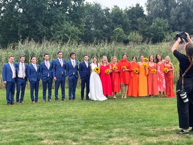 Groepsfoto van de bruidsstoet aan het rietveld op Speghelhof