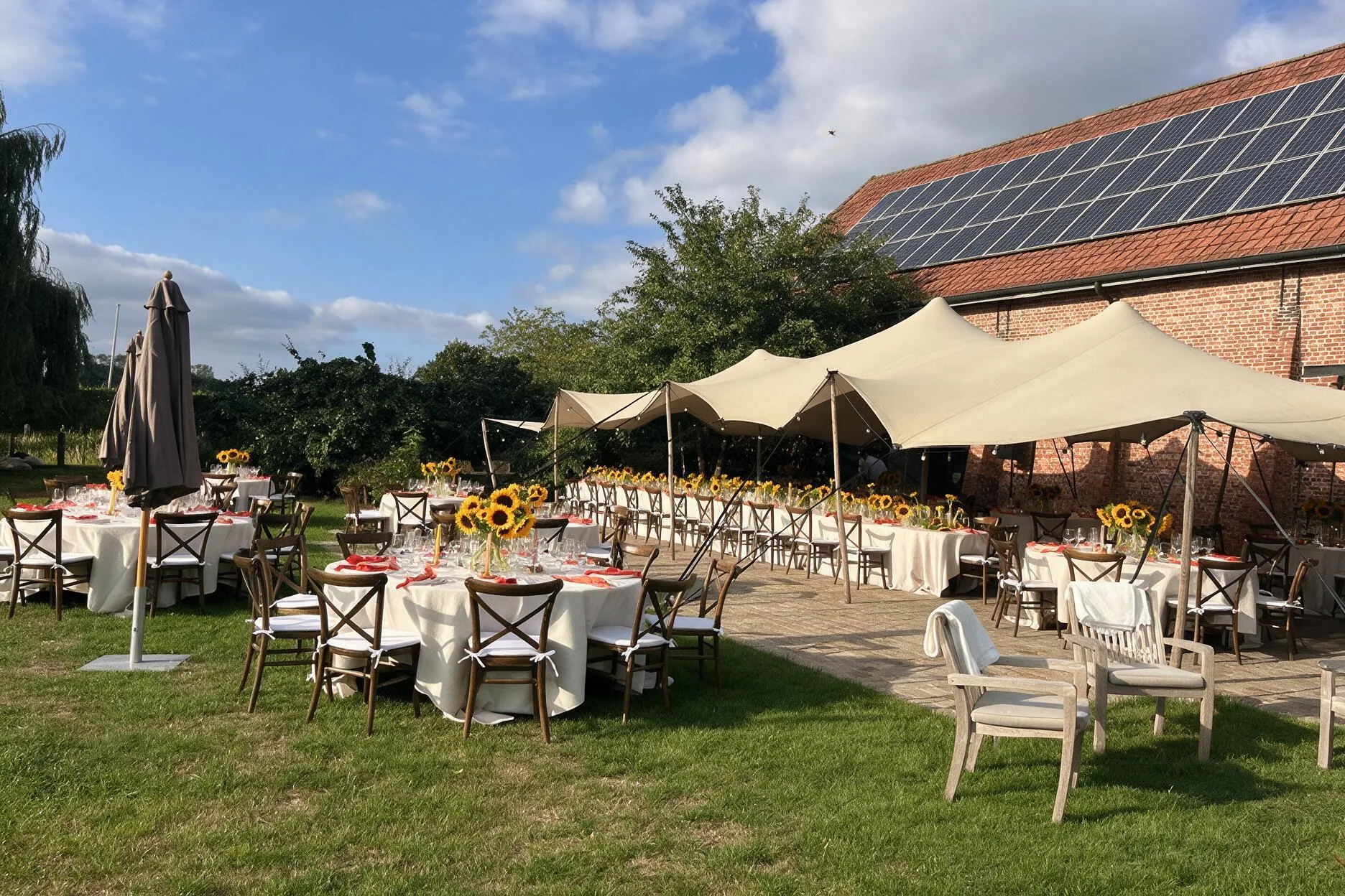 Diner onder de stretchtent in de tuin van Speghelhof met zonnebloemen