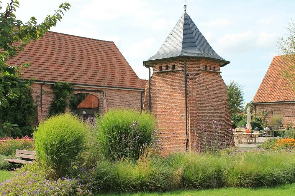 Historische duiventil tussen de siergrassen en bloemen van de landschapstuin op Speghelhof