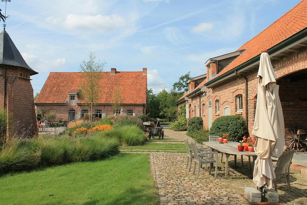 Gekasseid pad door de landschapstuin langs het terras naar de historische hoeve en duiventil van Speghelhof