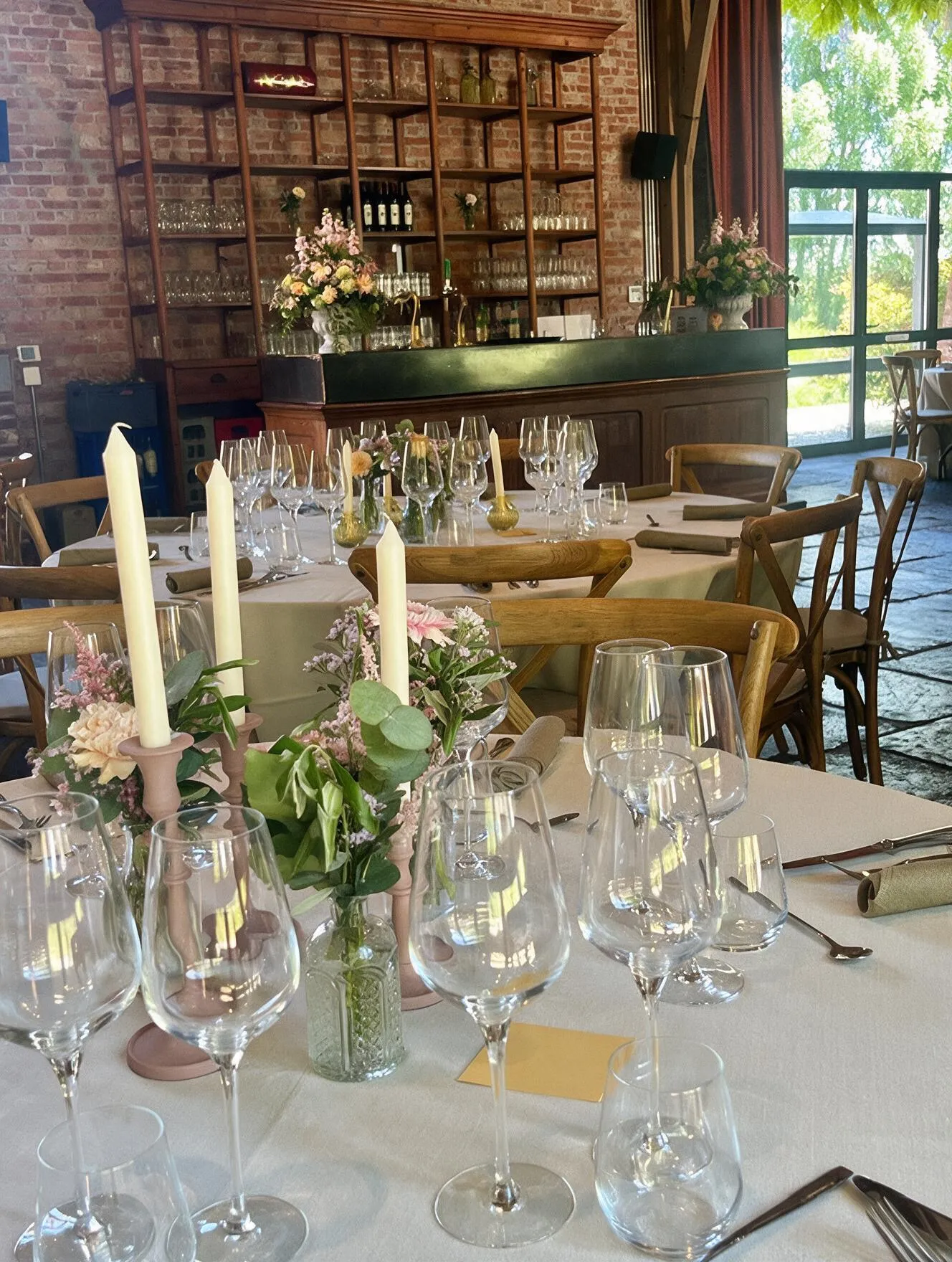Tafelschikking met kaarsen en bloemen bij de wijnbar in de schuur van Speghelhof