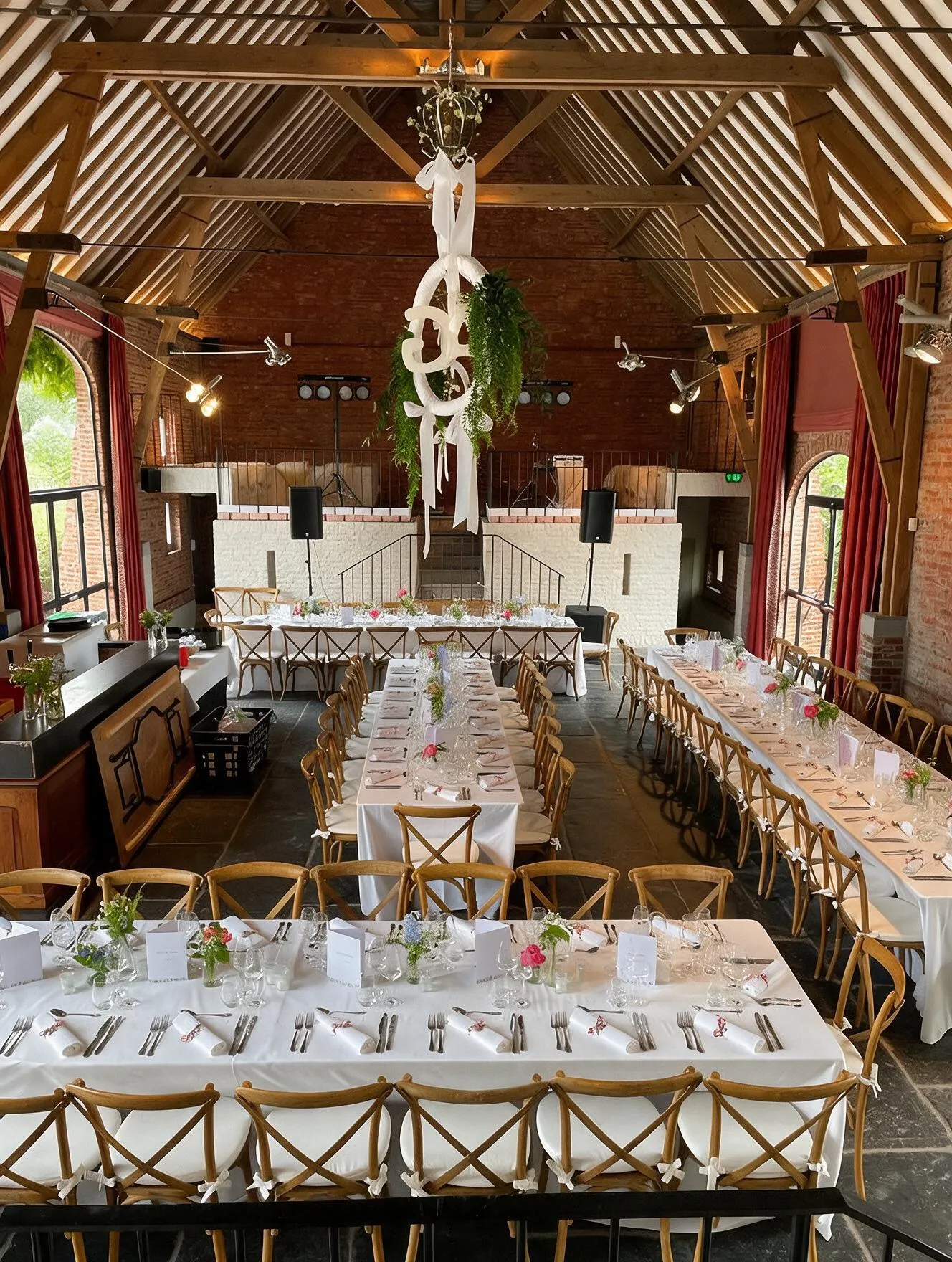 Volledig gedekte feestzaal met lange tafels voor een diner in de schuur van Speghelhof